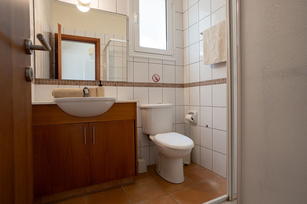 Modern bathroom with wooden vanity, sink and toilet
