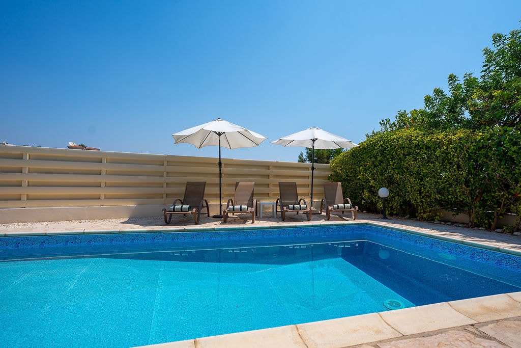 Swimming pool with sun loungers and umbrellas