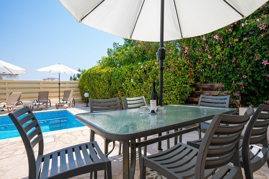 Patio dining area poolside with umbrella